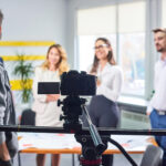 Group of business professionals discussing in front of a video camera during a corporate meeting for Business Videos