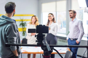 Group of business professionals discussing in front of a video camera during a corporate meeting for Business Videos