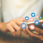 Video Production Insights by Doleep Studios 18 | video production costs Young man using a smartphone for social media video ads engagement