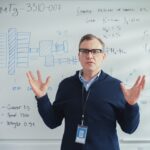 Professional male teacher giving a presentation on a whiteboard for whiteboard explainer videos